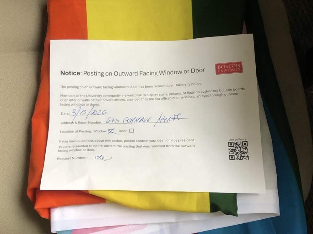 A note atop a folded pride flag explains why the banner was removed from professor Nathan Phillips' window. (Photo courtesy Nathan Phillips)