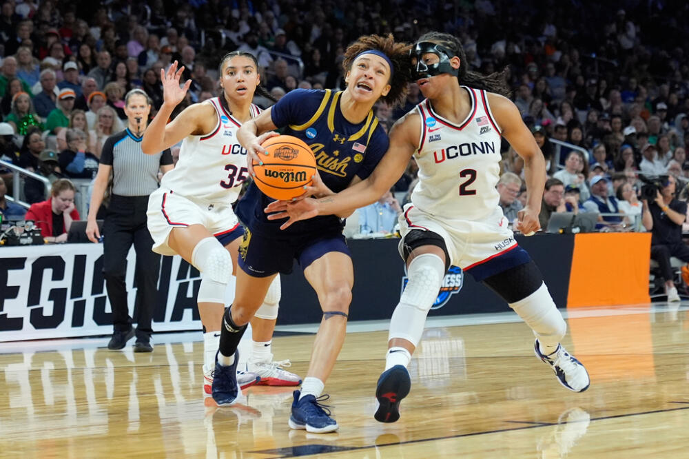 Notre Dame guard Hannah Hidalgo, center, drives against UConn guard KK Arnold (2) and guard Azzi Fudd (35) during the second half in the Elite Eight of the NCAA college basketball tournament, Sunday, March 29, 2026. (Tony Gutierrez/AP)