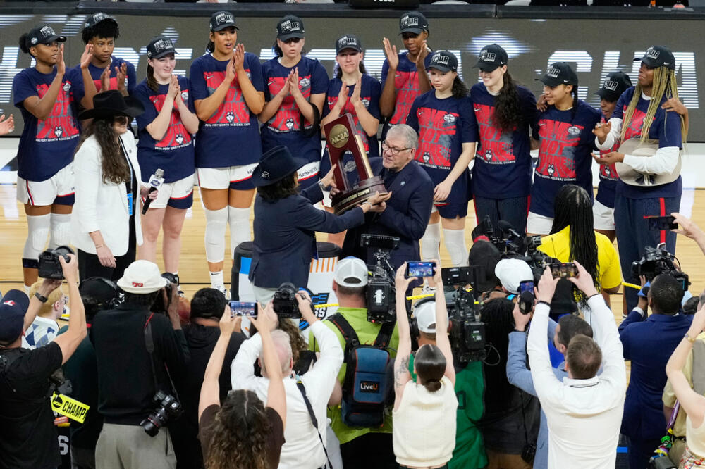 UConn head coach Geno Auriemma, center right, is presented with the Fort Worth Regional Champion trophy after his team defeated Notre Dame. (Tony Gutierrez/AP)