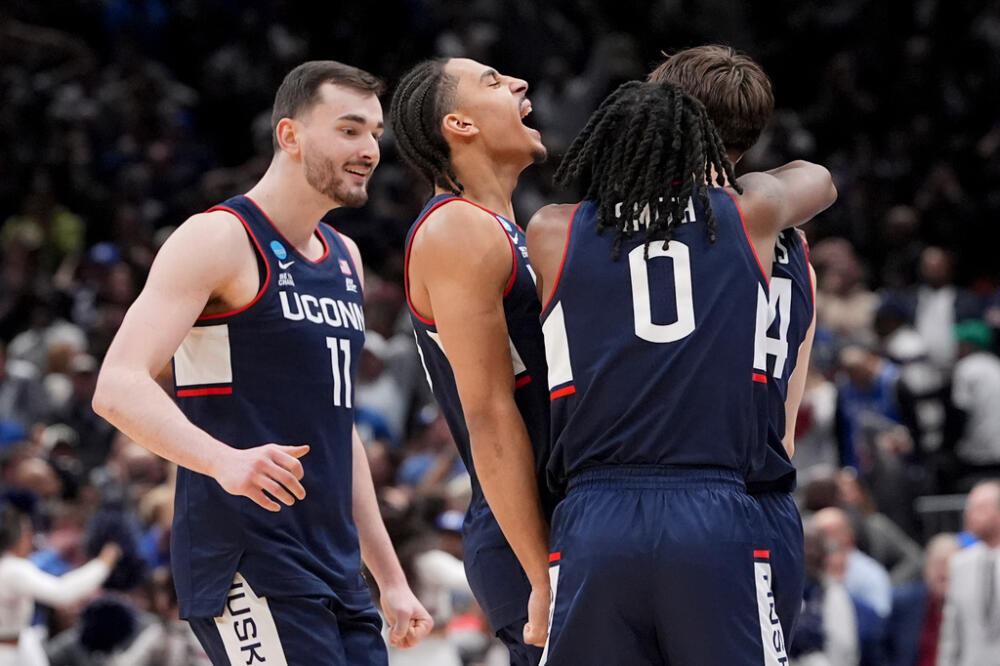 UConn guard Braylon Mullins, right, celebrates his game winning basket with guard Malachi Smith (0) during the second half in the Elite Eight of the NCAA college basketball tournament against Duke. (Stephanie Scarbrough/AP)