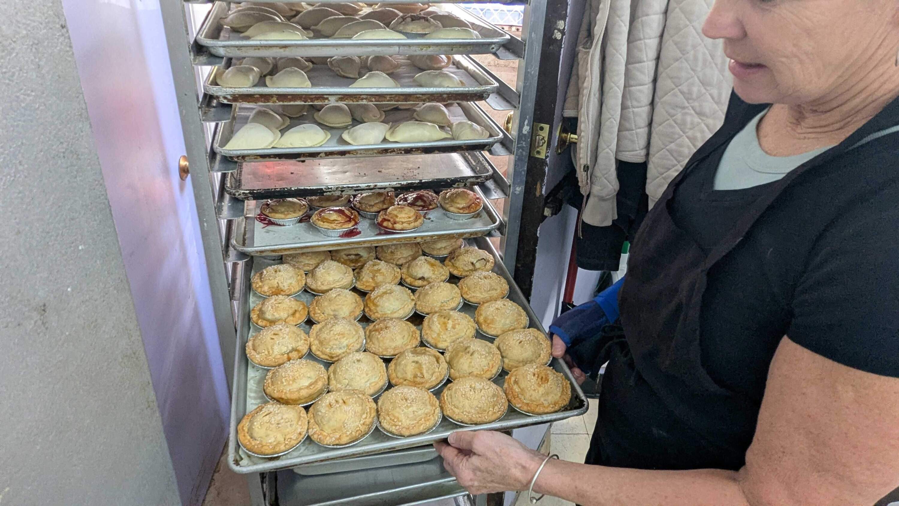 Kolenik displays a tray of miniature pies and hand pies prepared for Pi Day. (Hanna Ali/WBUR)