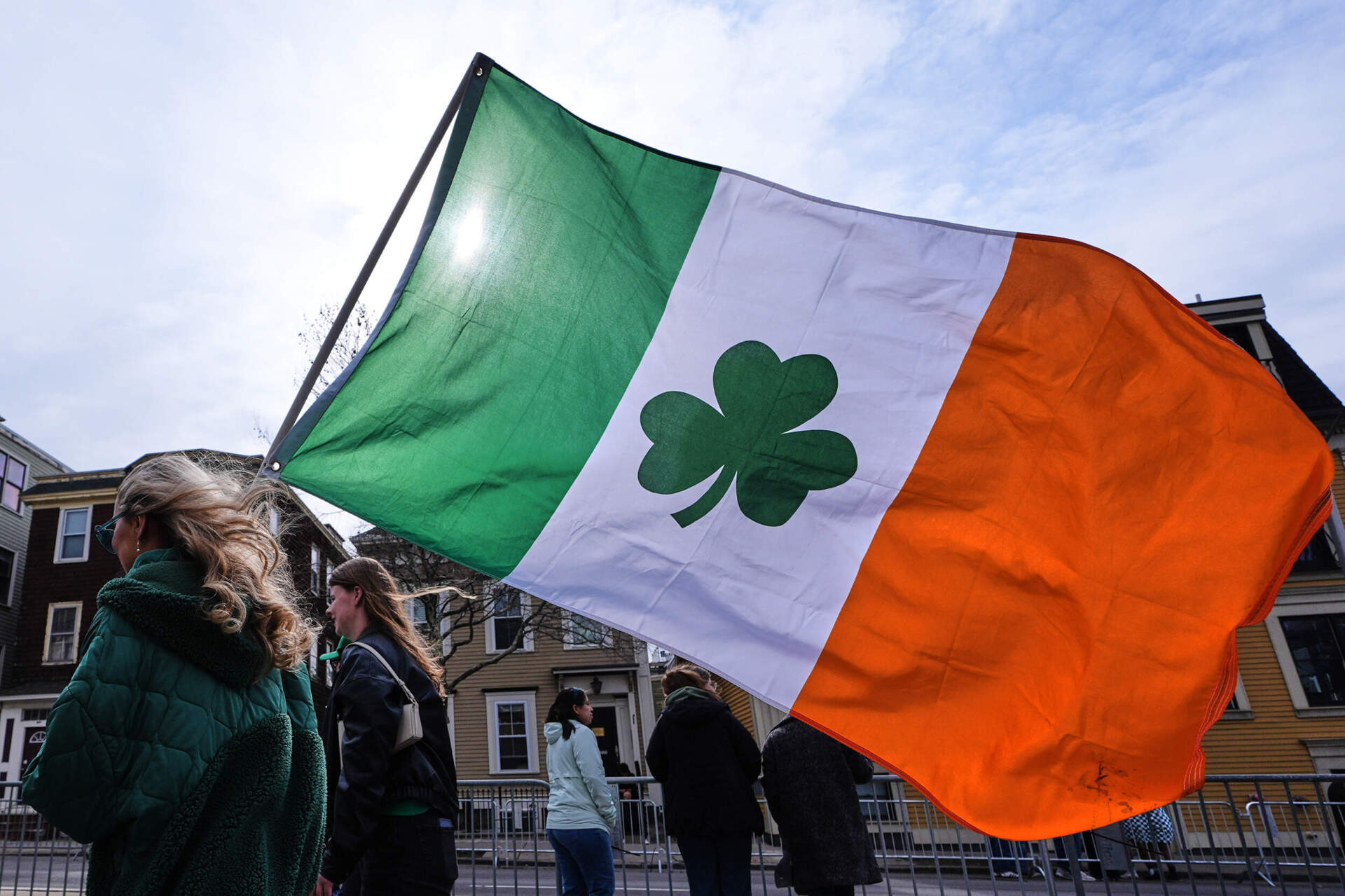 A spectator walks with an Irish shamrock flag during the annual St. Patrick's Day parade through South Boston. (Charles Krupa/AP)