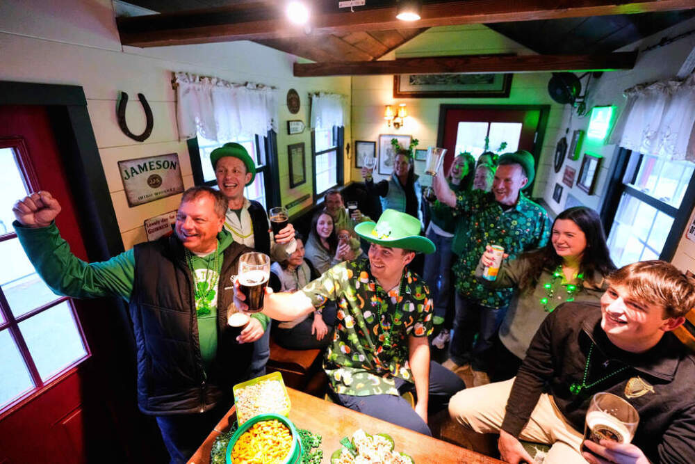 More than a dozen people pose for a photo while attending an early St. Patrick's Day party in a tiny pub, Friday, March 13, 2026. (Robert F. Bukaty/AP)