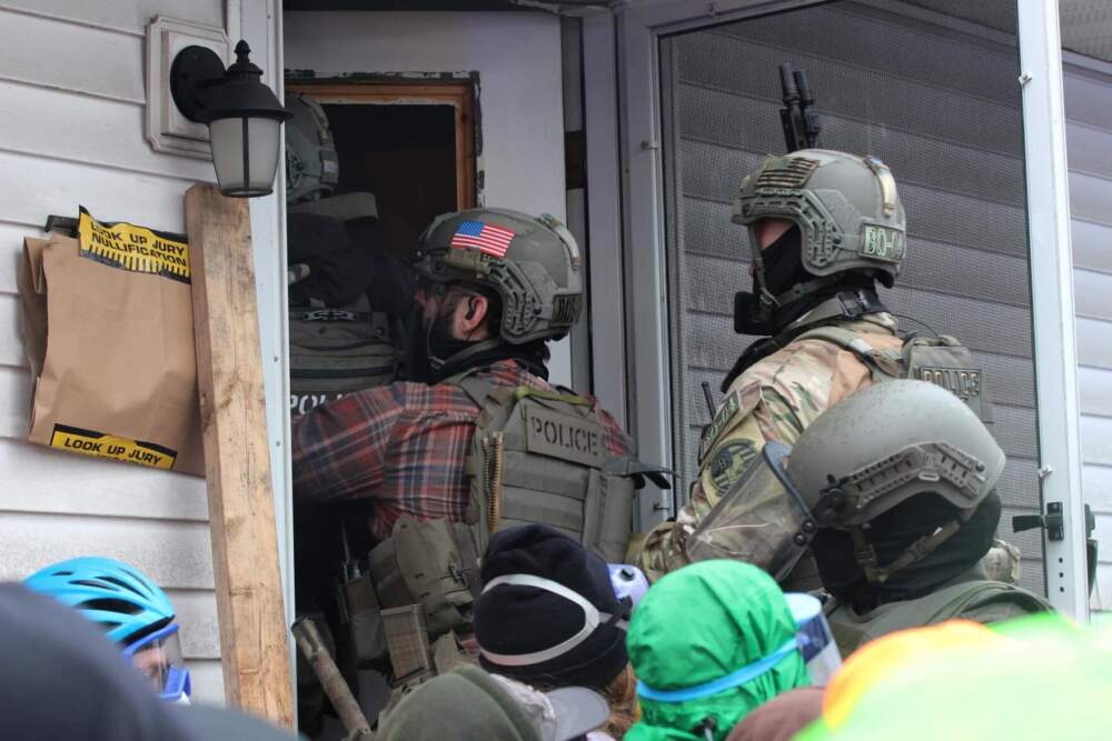 Immigration enforcement agents enter a South Burlington home to carry out an arrest. (Zoe McDonald/Vermont Public)