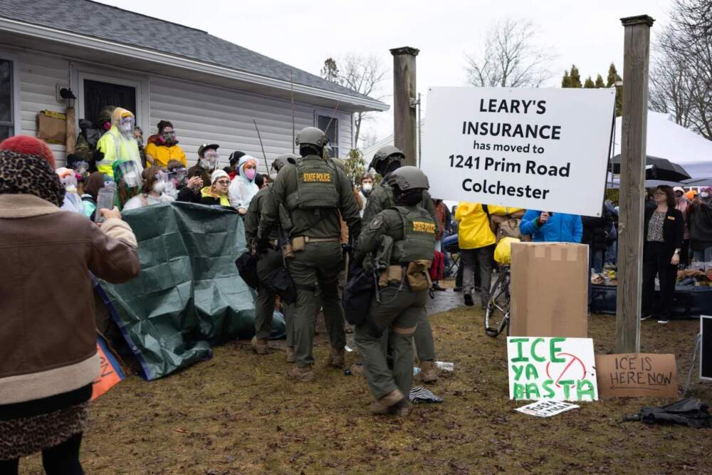 Vermont State Police prepare to clear protesters from the doorway of a South Burlington home where ICE planned to make an arrest.(Zoe McDonald/Vermont Public)