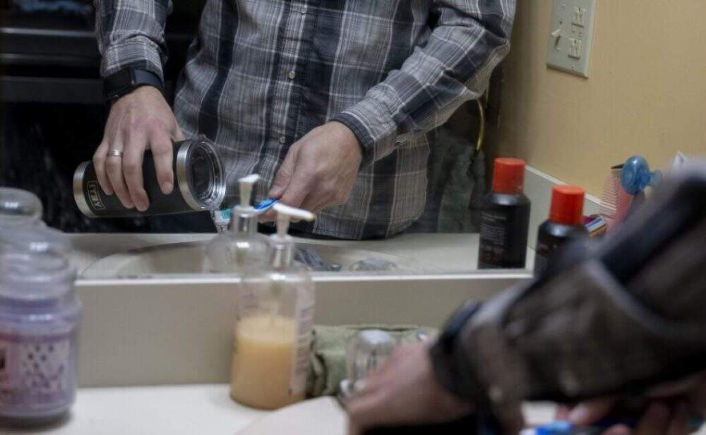 A Londonderry resident demonstrates how to brush your teeth with bottled water. 