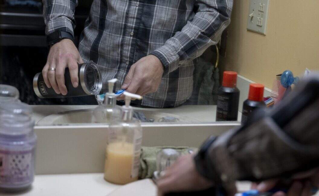 A Londonderry resident demonstrates how he brushes his teeth with bottled water.