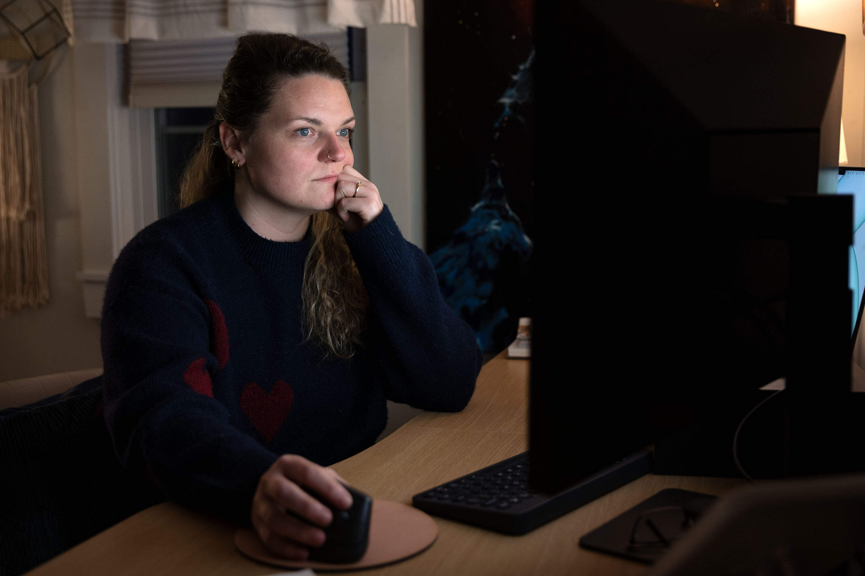 Suzi Sanford sits at her computer, using the AI chatbot Claude, at her home in Fitchburg, Mass. (Robin Lubbock/WBUR)
