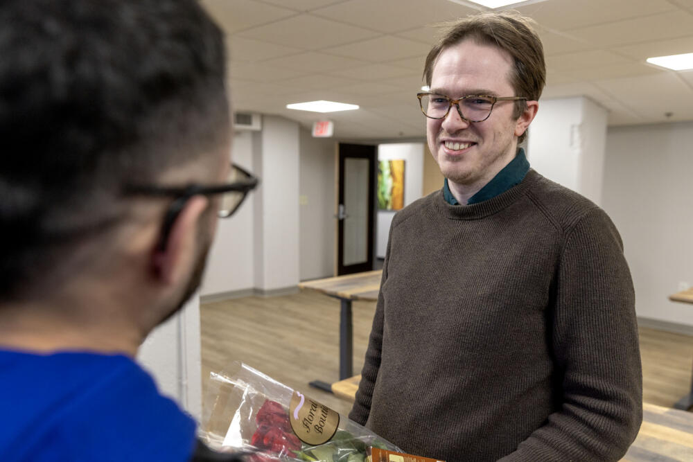 Luke Morrell, a paralegal with the detention team at the PAIR Project, talks with Alejandro Orrego Agudelo after Orrego's release from ICE custody. (Robin Lubbock/WBUR)