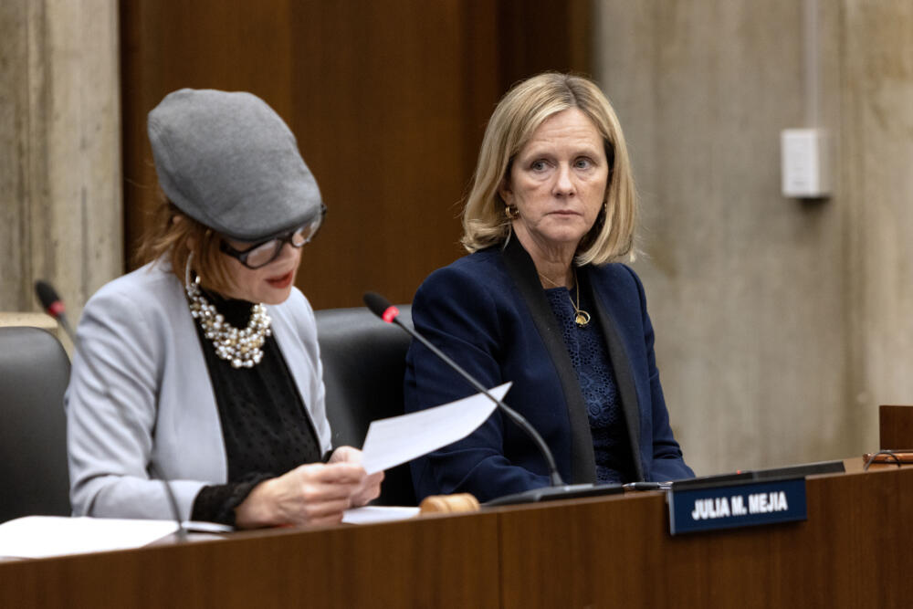 Boston City Councilor Erin Murphy, on right, listens to City Councilor Julia Mejia at a meeting to discuss transportation for Boston Public Schools. (Robin Lubbock/WBUR)