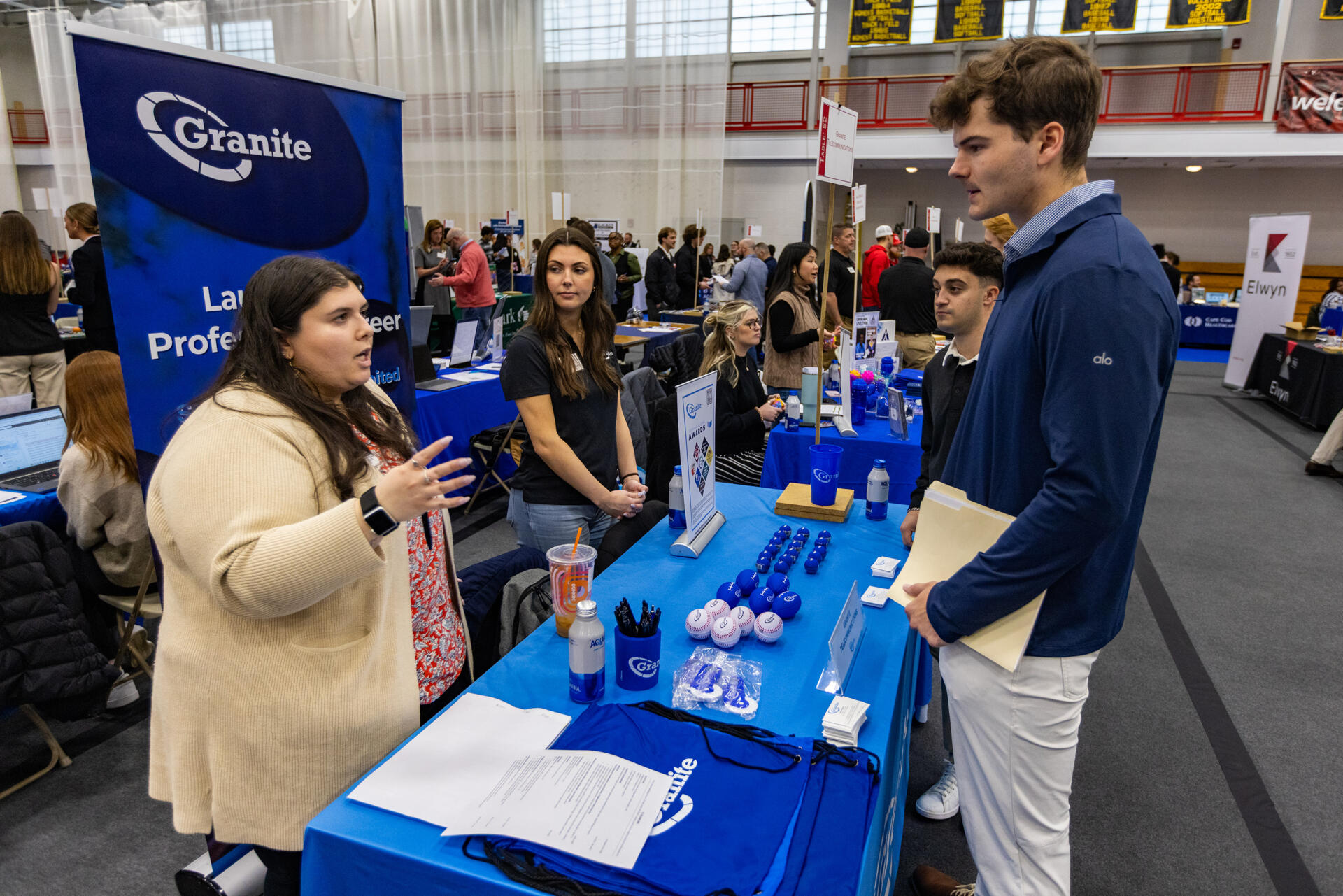 Senior Louie Jennings listens to a representative from Granite Telecommunications during the Bridgewater State University's MEGA Job & Internship Fair. (Jesse Costa/WBUR)