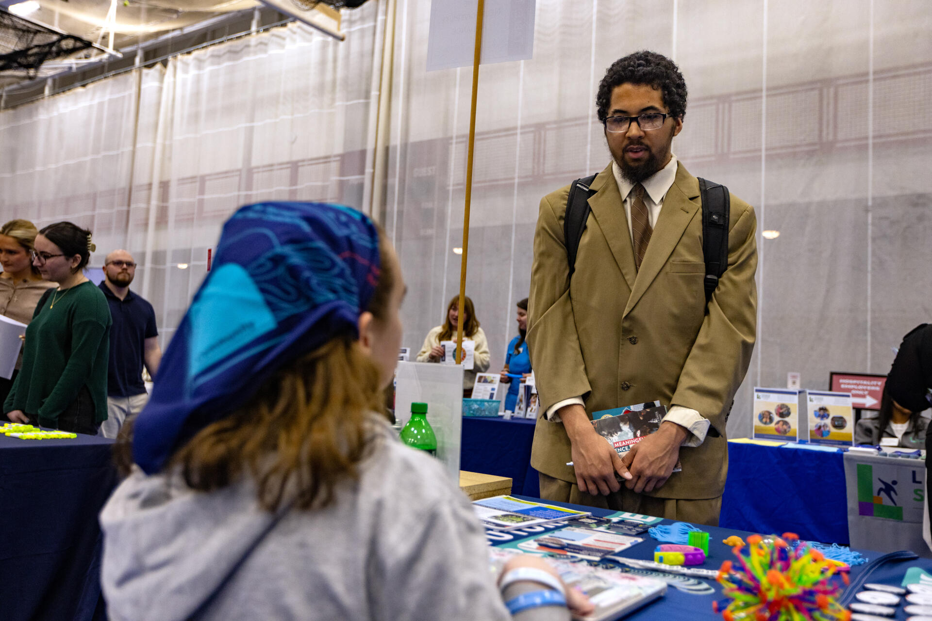 Senior Albert Reyes speaks with Lorelei Wales from the Neurodiversity Alliance during the Bridgewater State University's MEGA Job & Internship Fair. (Jesse Costa/WBUR)
