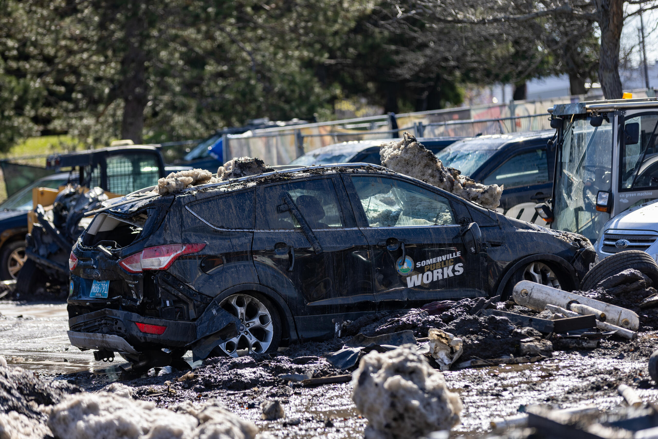 A Somerville city vehicle that was previously removed from a massive snow pile in a vacant lot on Washington Street. (Jesse Costa/WBUR)