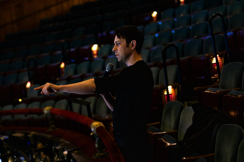 John de los Santos directs the cast of BLO's "Daughter of the Regiment" from the balcony during a rehearsal at the Emerson Colonial Theatre. (Jesse Costa/WBUR)