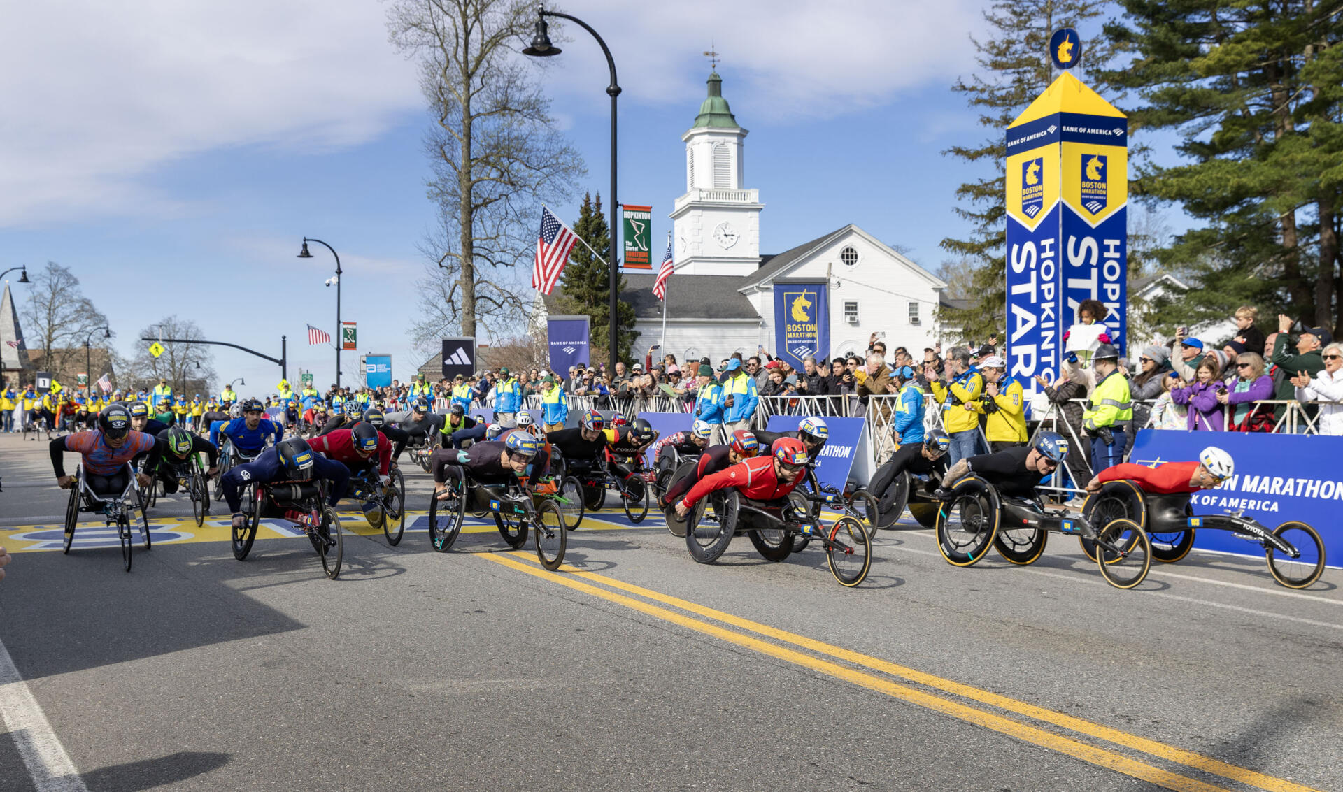 Competitors in the men's wheelchair division of the 130th Boston Marathon cross the start line. (Robin Lubbock/WBUR)