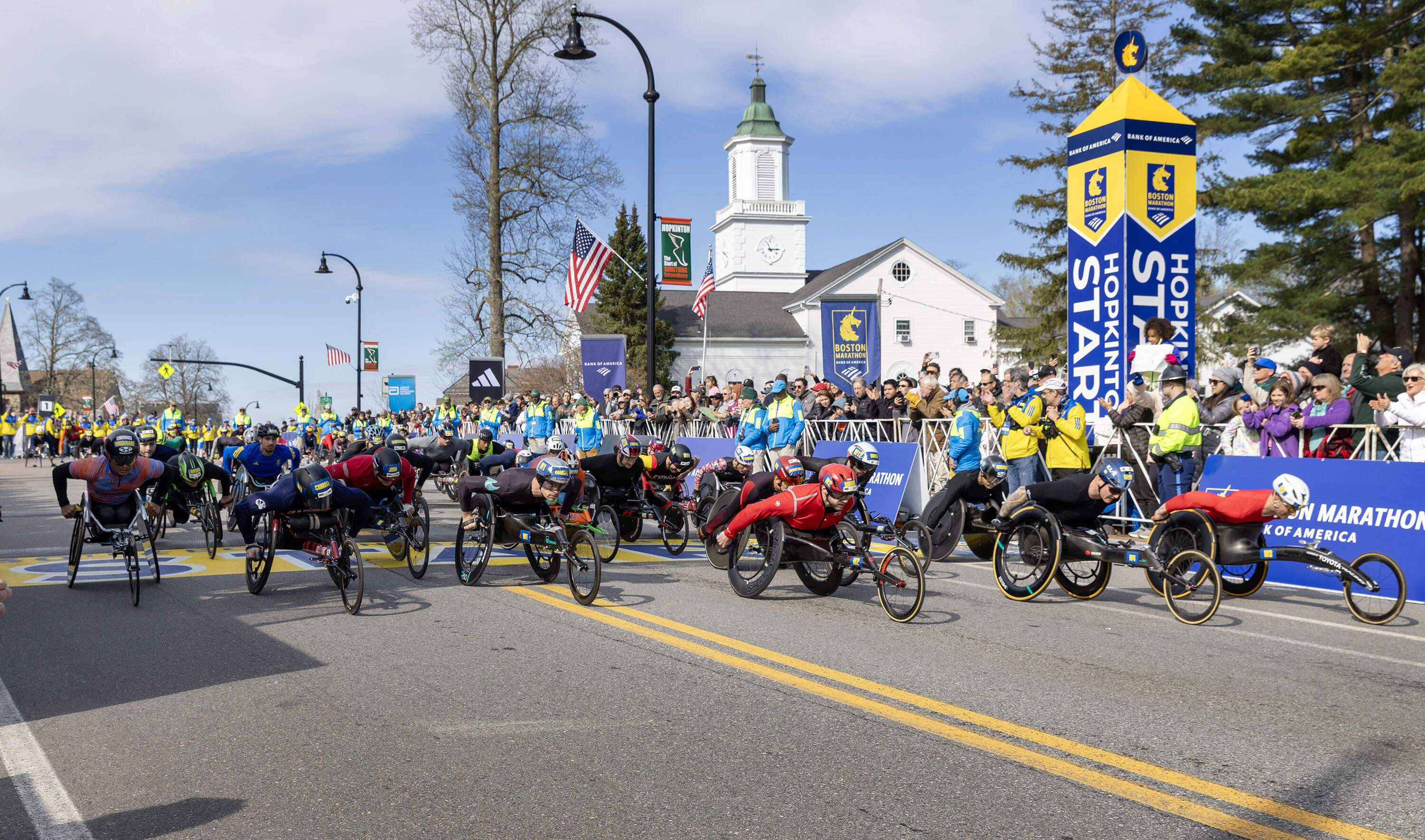 Competitors in the men's wheelchair division of the 130th Boston Marathon cross the start line. (Robin Lubbock/WBUR)