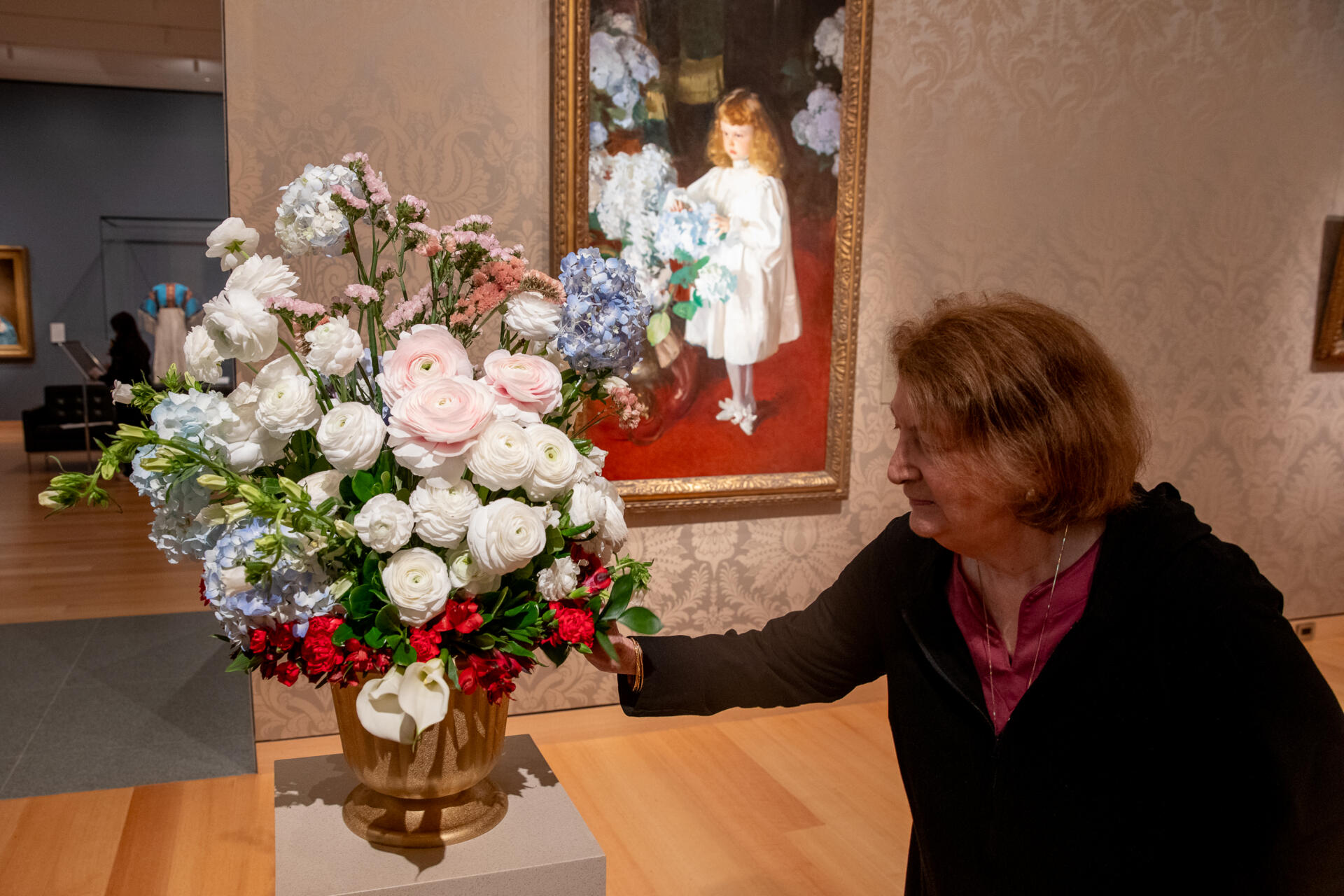 Seta Lepore of the Belmont Garden Club puts the final touches on her floral arrangement inspired by John Singer Sargent's 1895 painting “Helen Sears." (Artemisia Luk/WBUR)