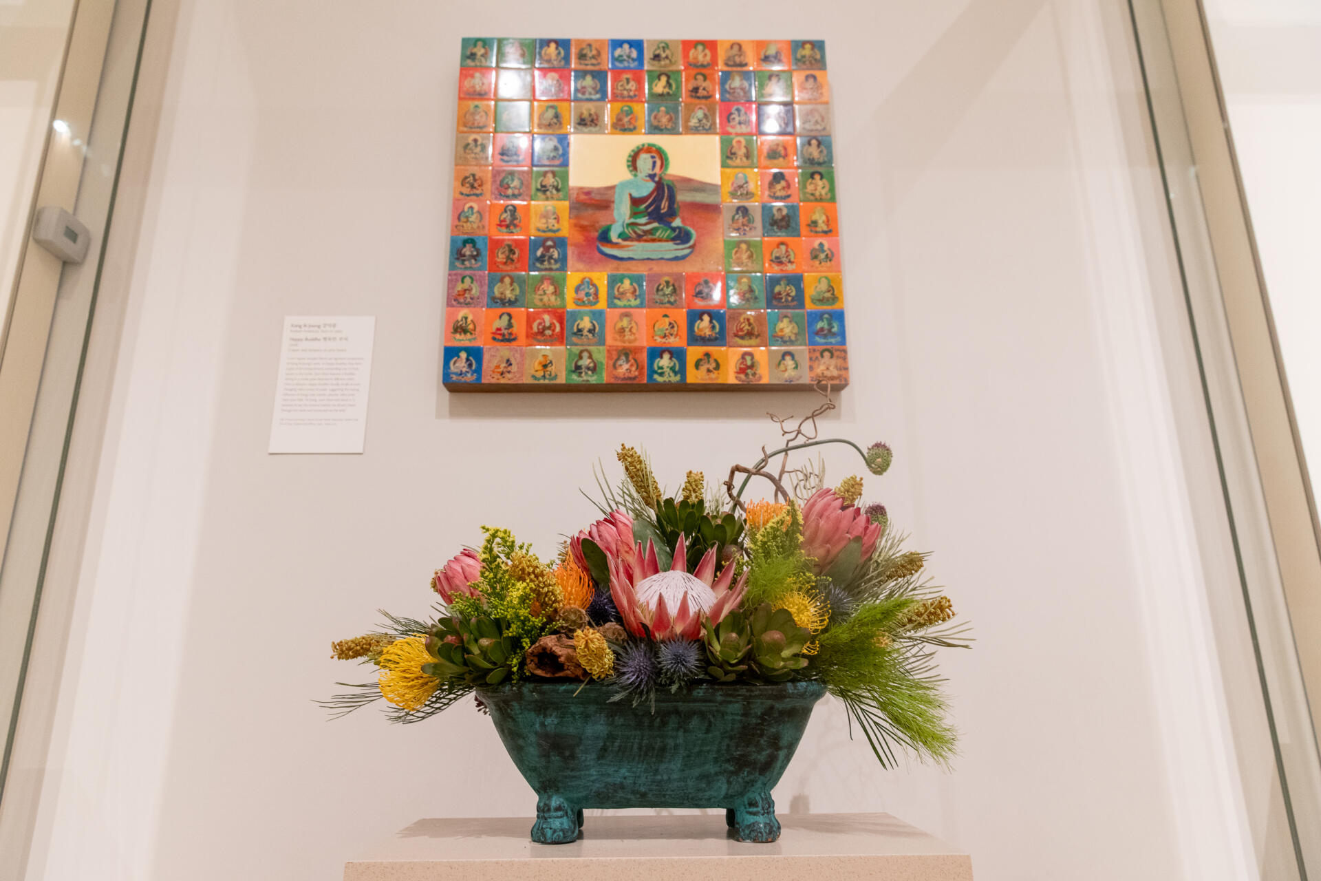 A floral arrangement from Vinfen’s Gateway Arts inspired by the print “Happy Buddha” by Kang Ik-Joong. (Artemisia Luk/WBUR)