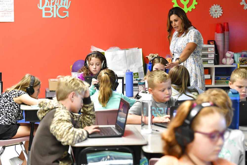 Angela Pike watches her fourth grade students at Lakewood Elementary School in Cecilia, Ky., as they use their laptops to participate in an emotional check-in at the start of the school day, Thursday, Aug. 11, 2022. (AP Photo/Timothy D. Easley)