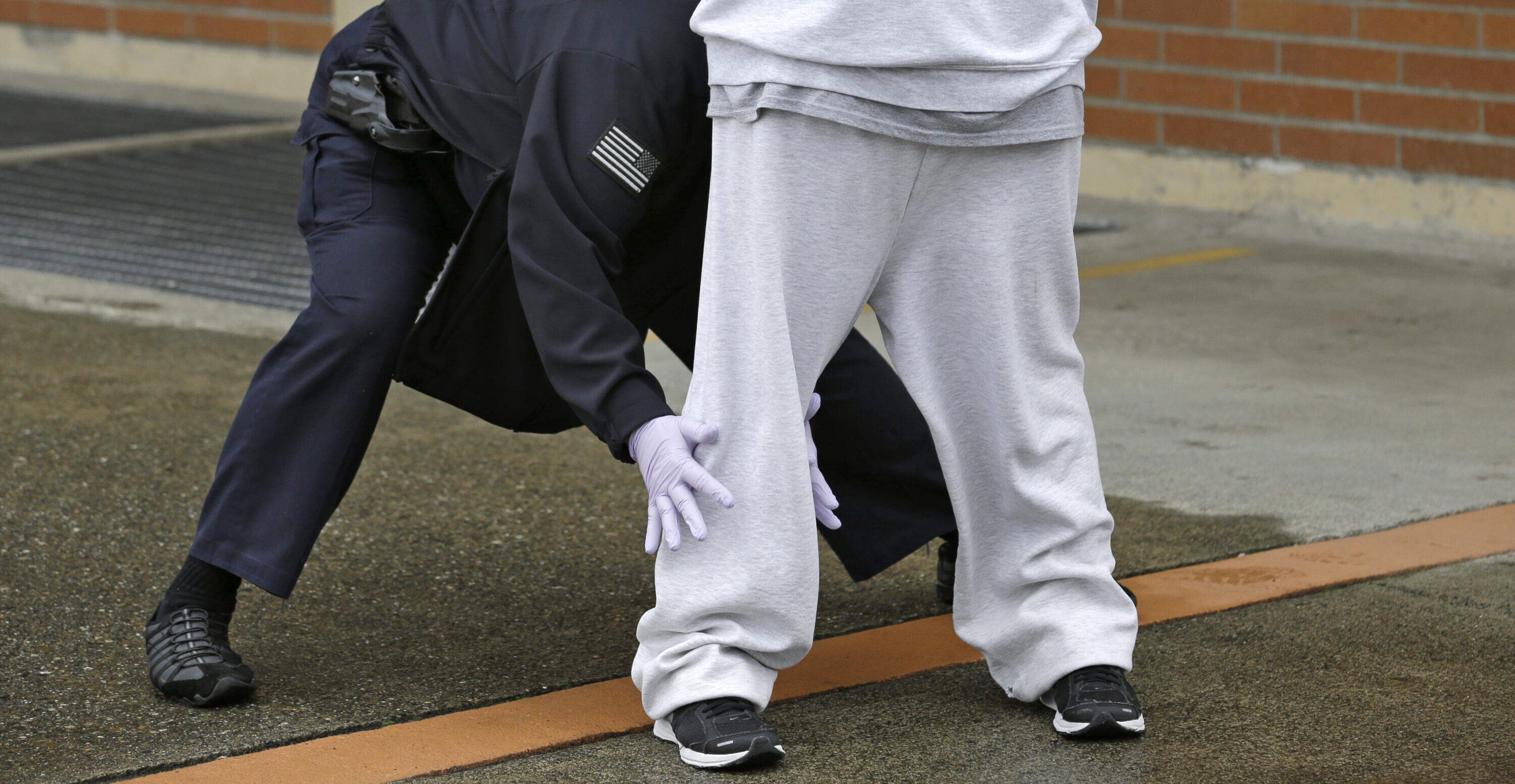 An offender is searched by a correctional officer (Elaine Thompson/AP)