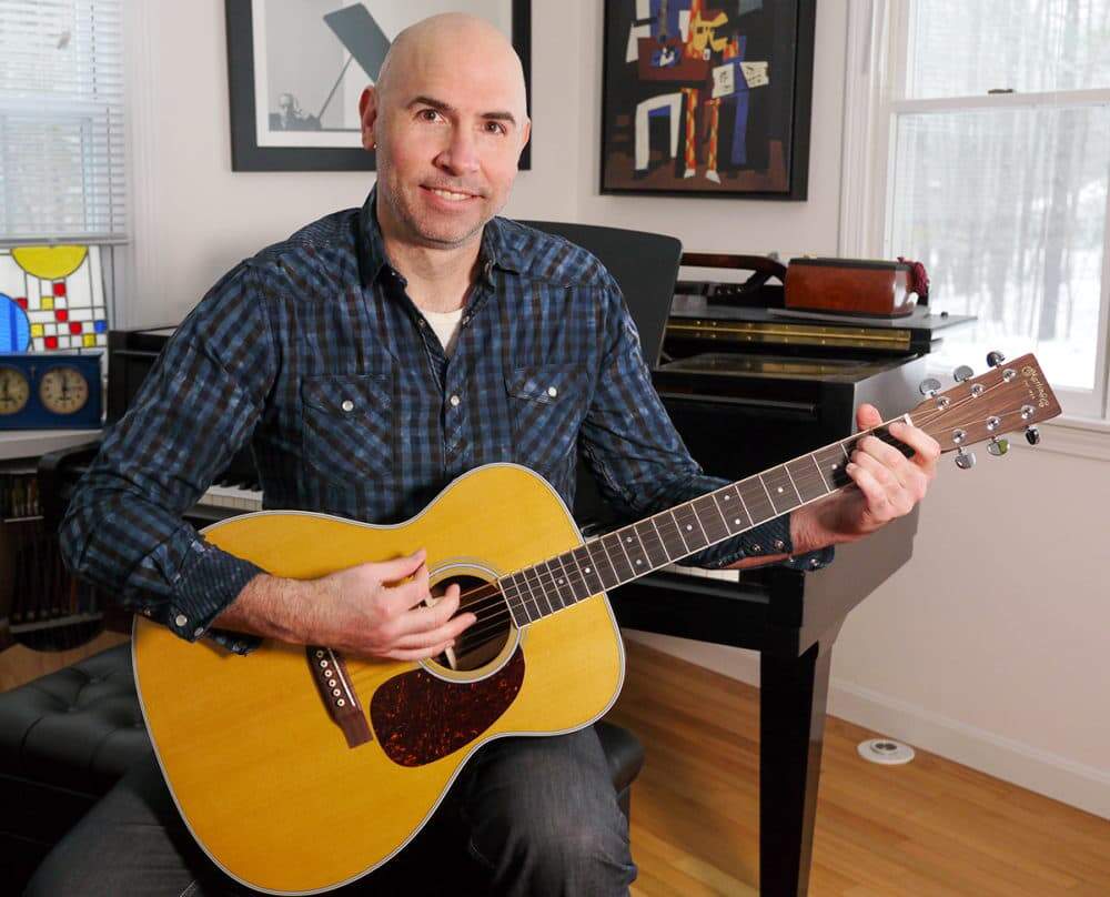 The acoustic guitar – like this one being played by composer Eric Shimelonis – makes sound naturally. It needn’t be plugged into an amplifier like an electric guitar does. (image courtesy of Rebecca Sheir)