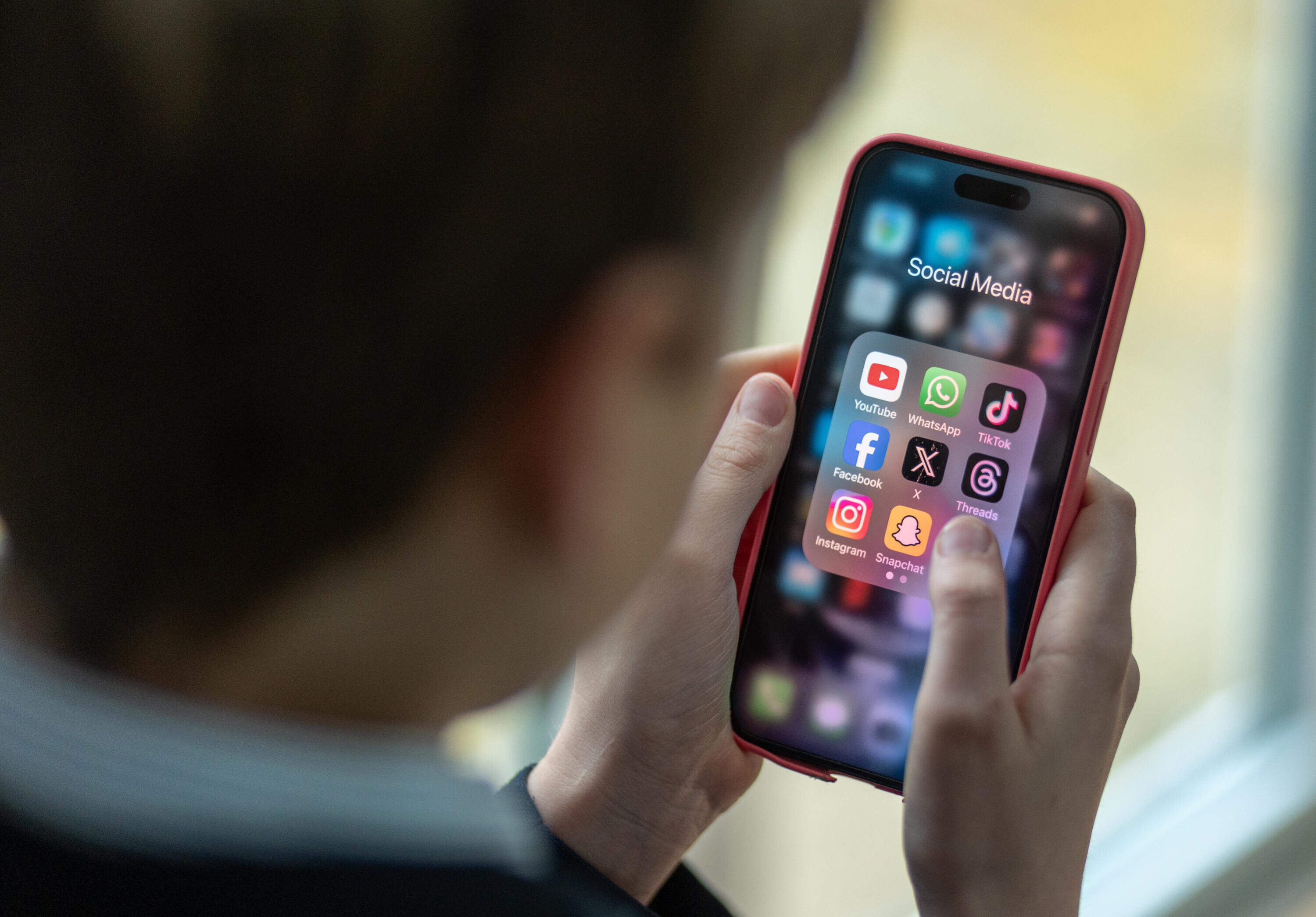 In this photo illustration, a 12-year-old school boy looks at a iPhone screen.