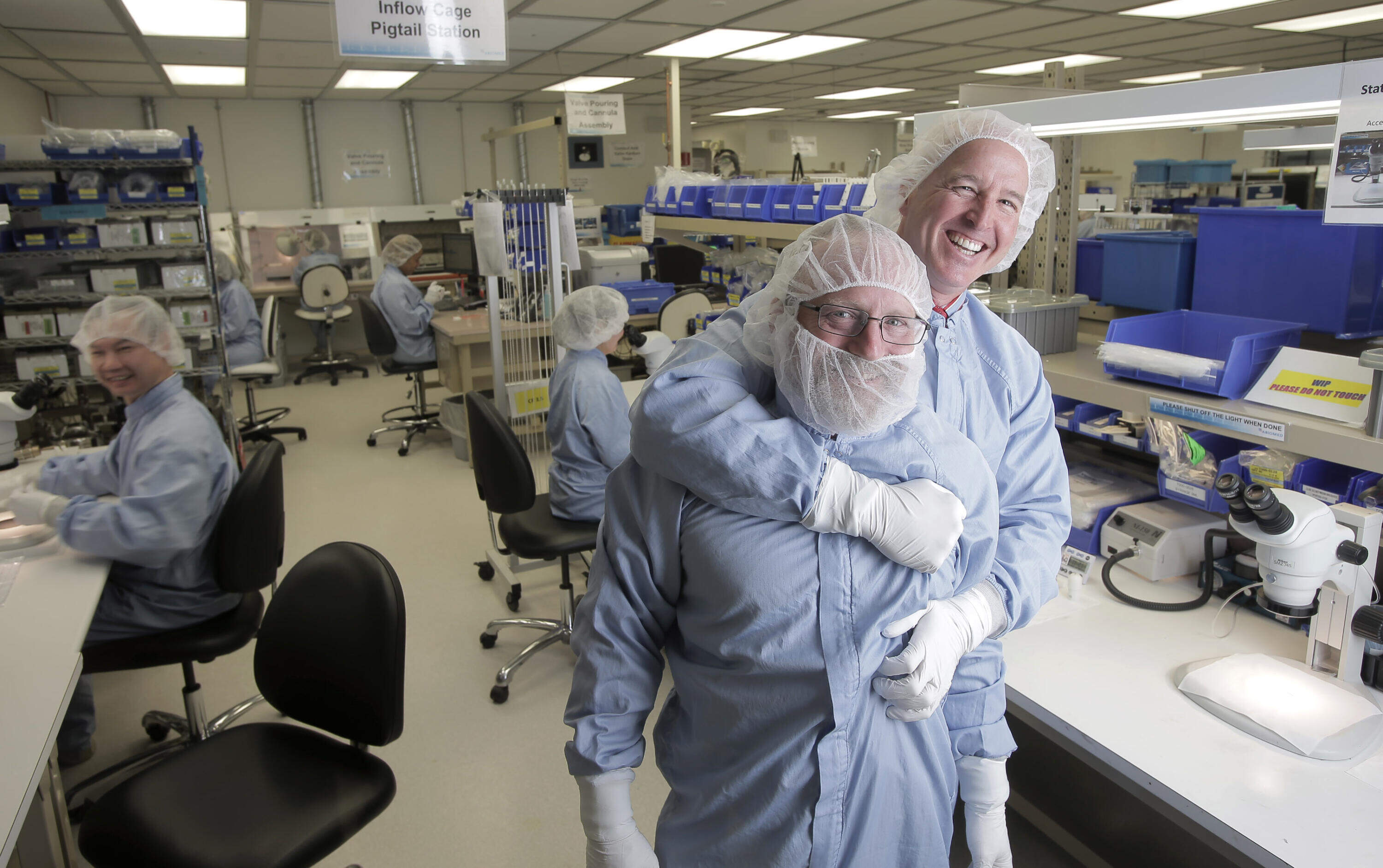 In this 2015 photo, Minogue shared a lighthearted moment with production manager Vernon Rothrock in the Abiomed "clean room" manufacturing facility in Danvers. (Lane Turner/The Boston Globe via Getty Images)