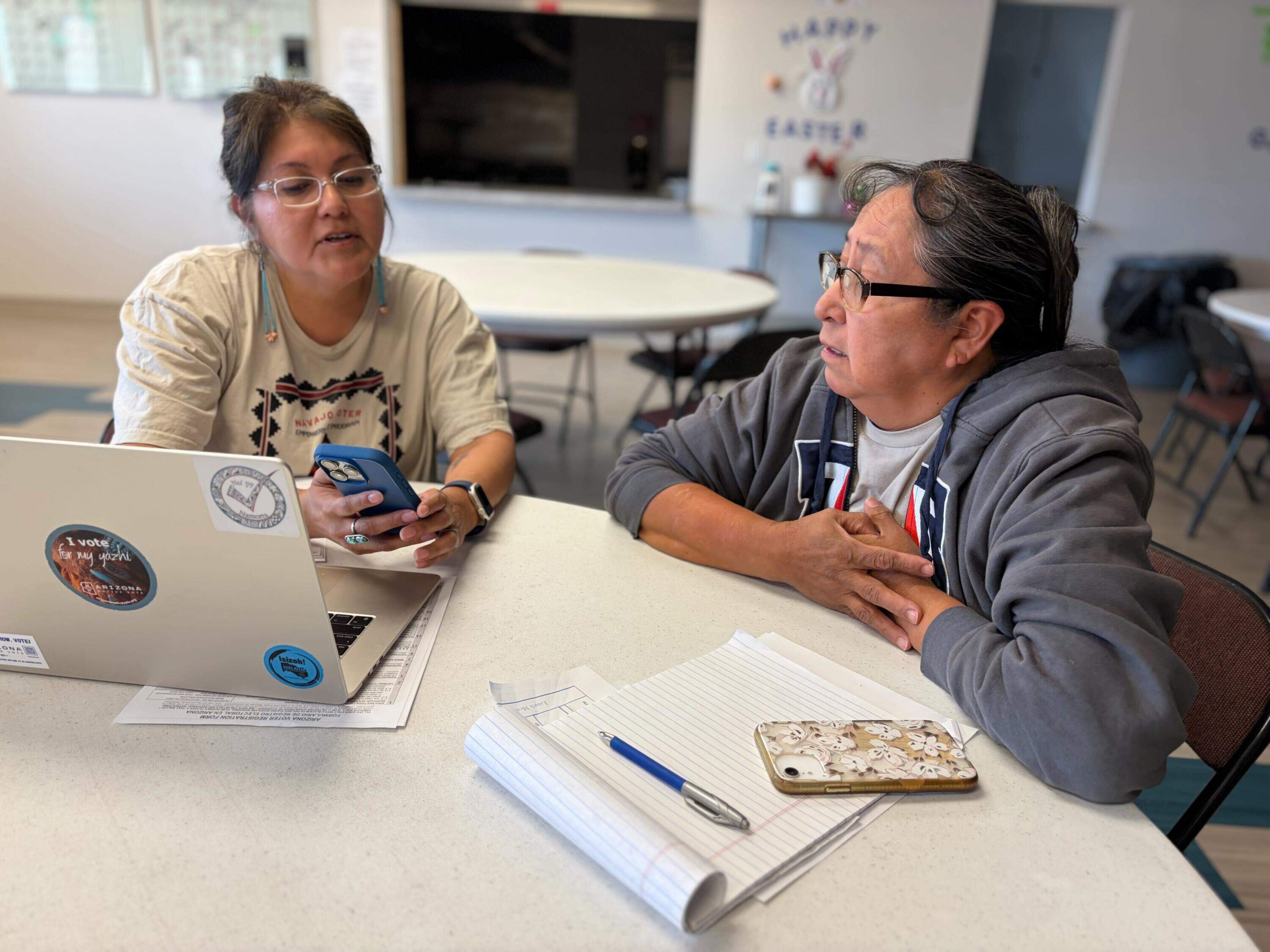After some confusion during the 2024 election, Arizona Native Vote’s Jayne Parrish, left, helps Navajo Nation resident Betty John figure out where she should go to cast her ballot for the upcoming midterms. (Peter O’Dowd/Here &amp; Now)