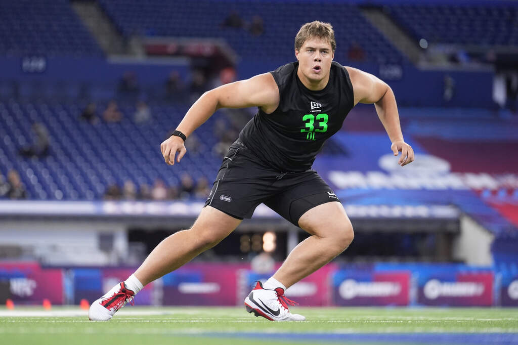 Utah offensive lineman Caleb Lomu (33) runs a drill at the NFL football scouting combine in Indianapolis, March 1, 2026. (Michael Conroy/AP, File)