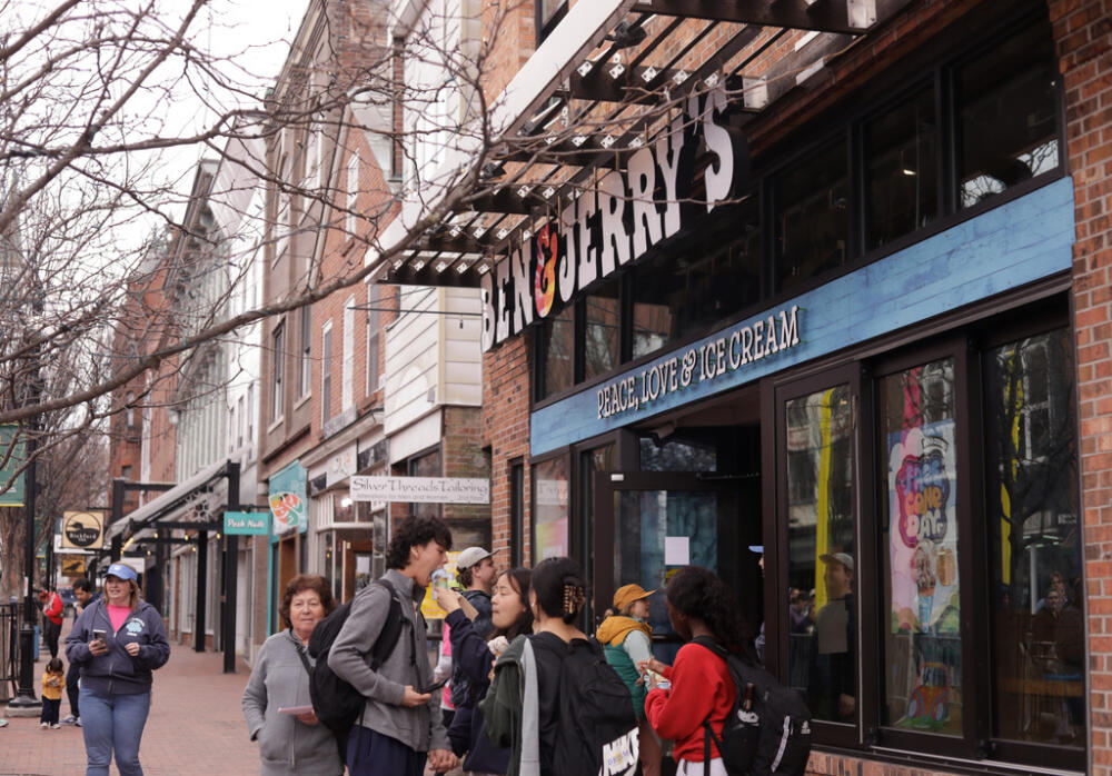 People eat ice cream outside the Ben &amp; Jerry's scoop shop on Free Cone Day in Burlington, Vt., Tuesday, April 14, 2026. (Amanda Swinhart/AP)