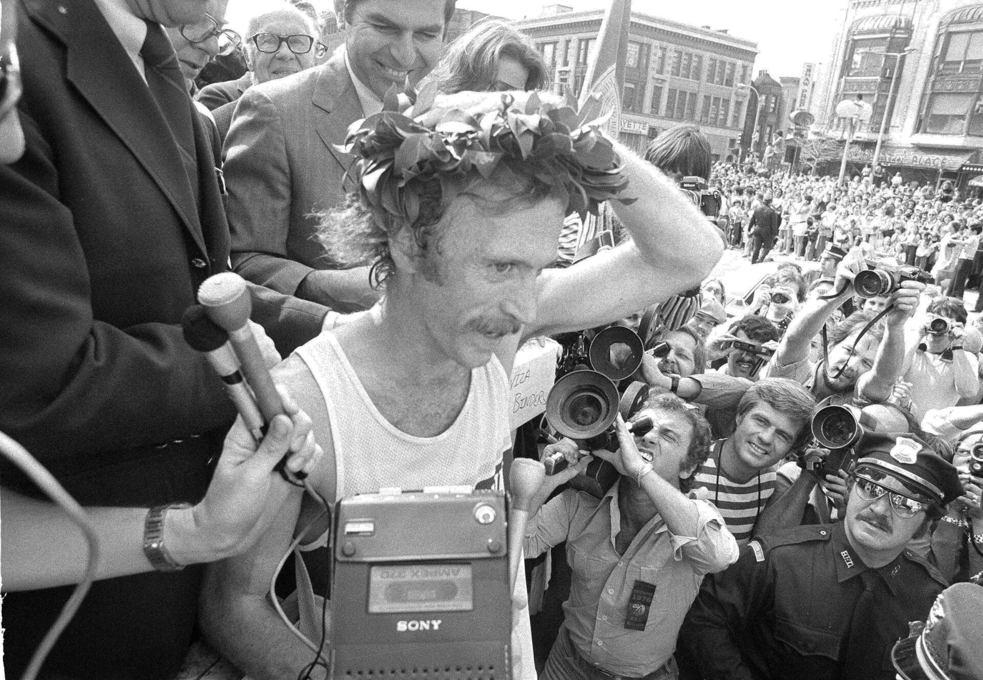 Jack Fultz hangs on to his wreath after being crowned the winner of the Boston Marathon on April 19, 1976. He finished the race in 2:20:19. Behind Fultz is Gov. Michael Dukakis. (AP file)
