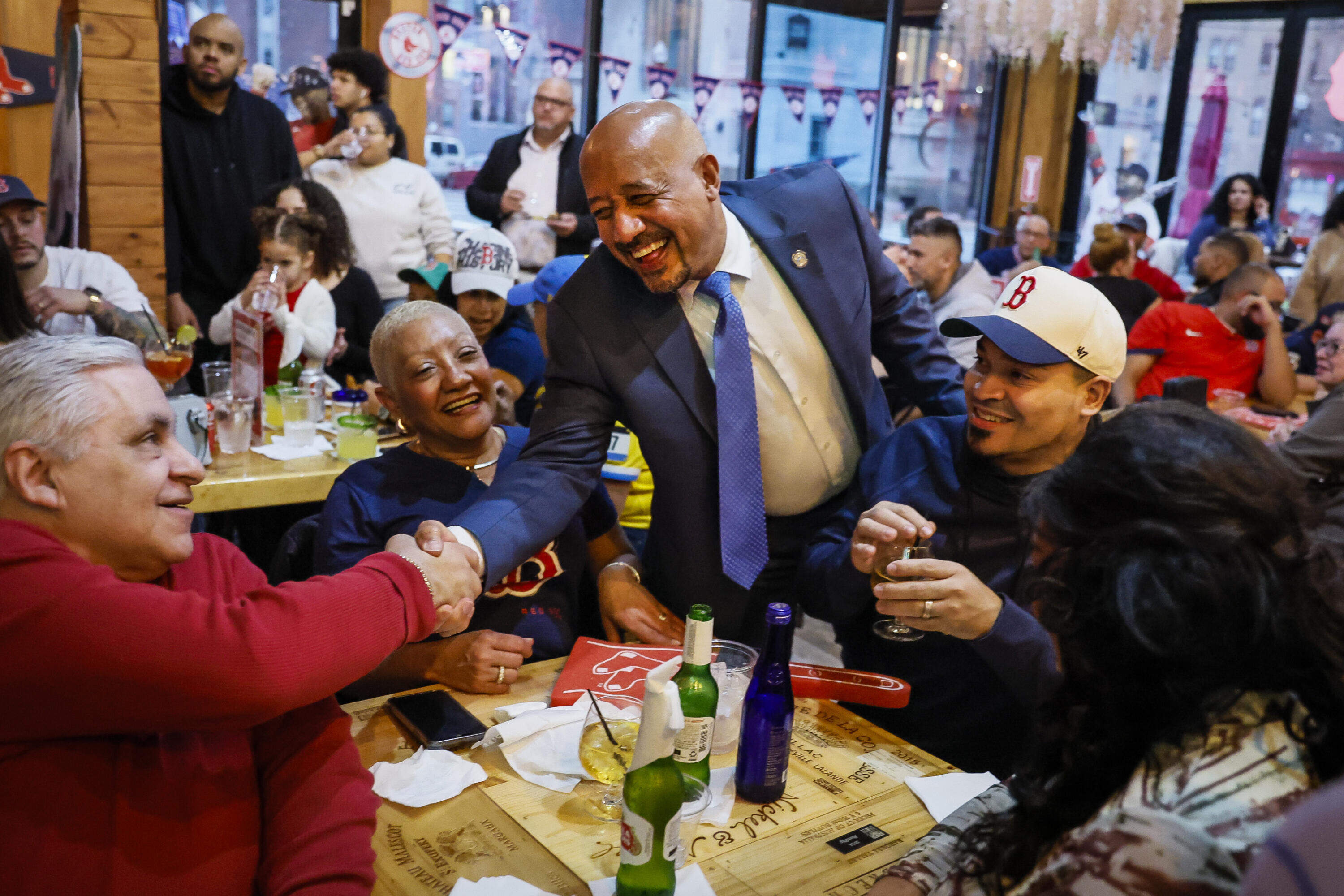 Lawrence Mayor Brian DePeña greets attendees at Terra Luna Cafe, a Dominican-owned restaurant during a community watch party of a Boston Red Sox game in 2024. (Erin Clark/The Boston Globe via Getty Images)