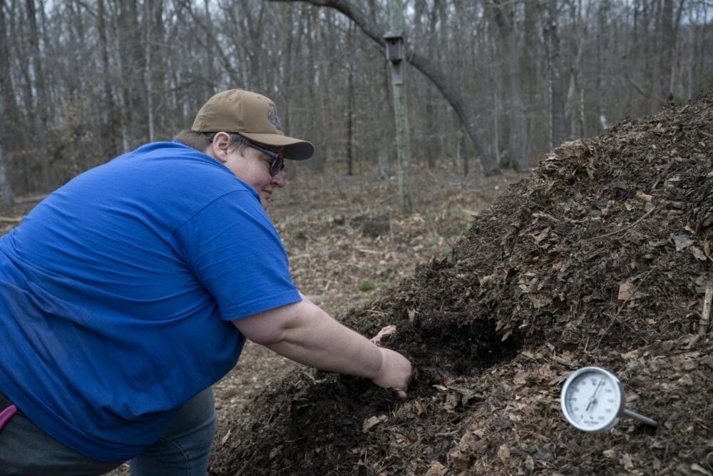 Baylee Drown, farmer and operator of Long Table Farm, sifts through compost on their farm in Lyme, Conn. Efforts like adding compost reduce the need for fertilizer, some of which is made with fossil fuels, and requires less machinery, which means less need for gas. (Raquel C. Zaldívar/New England News Collaborative)