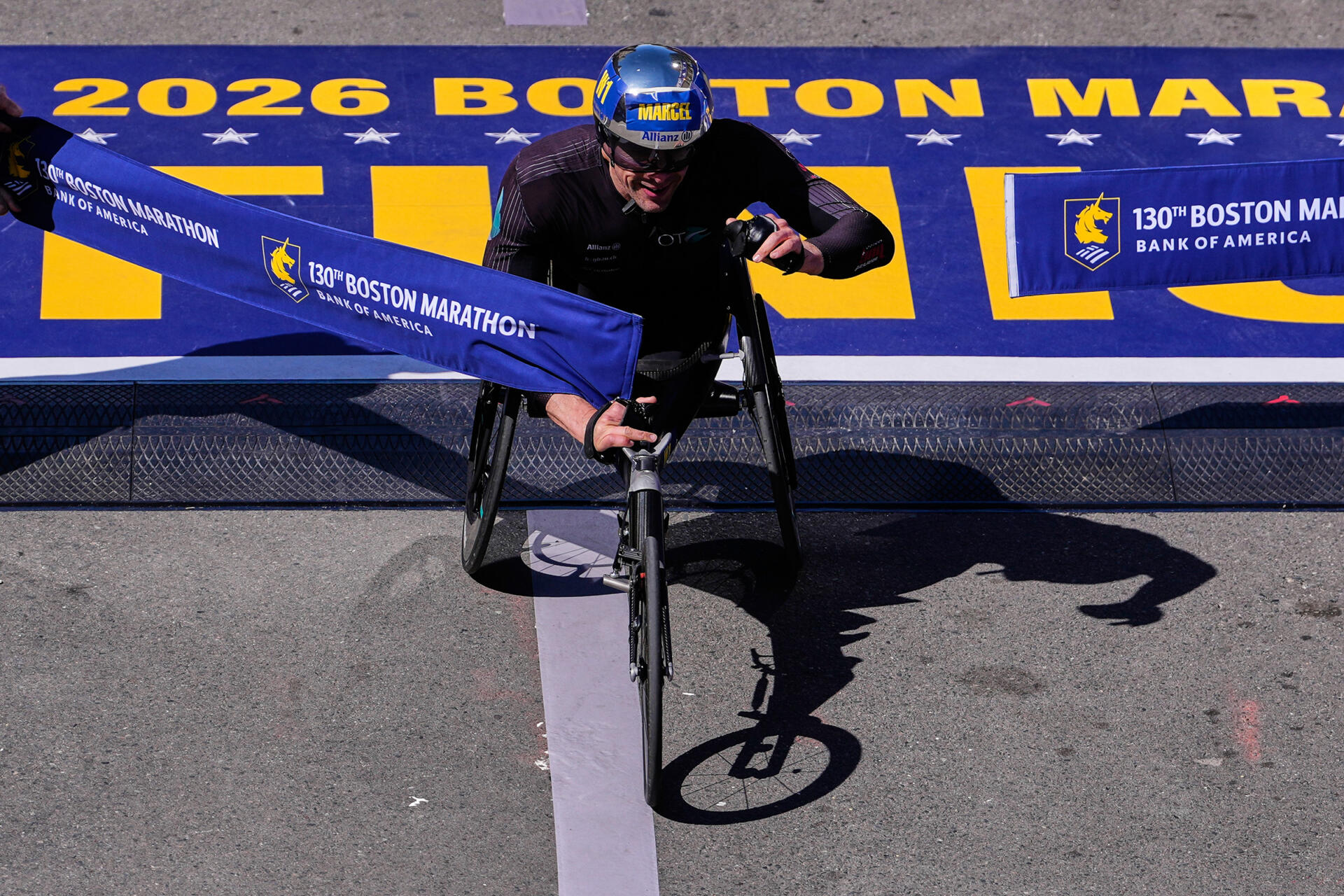 Marcel Hug, of Switzerland, breaks the tape to win the men's wheelchair division at the Boston Marathon on April 20, 2026. (Charles Krupa/AP)