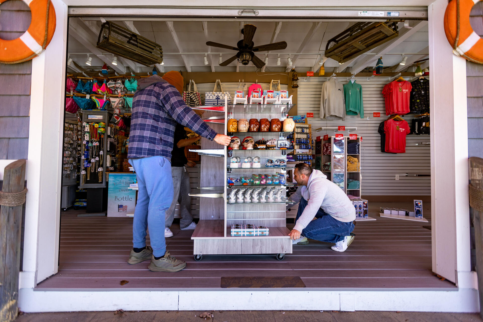 Orren Vacnin, right, and his crew move a display case at Orren’s Island Gift Shop at Wicked Waves Water Park in Yarmouth to prepare for the upcoming summer season. (Jesse Costa/WBUR)