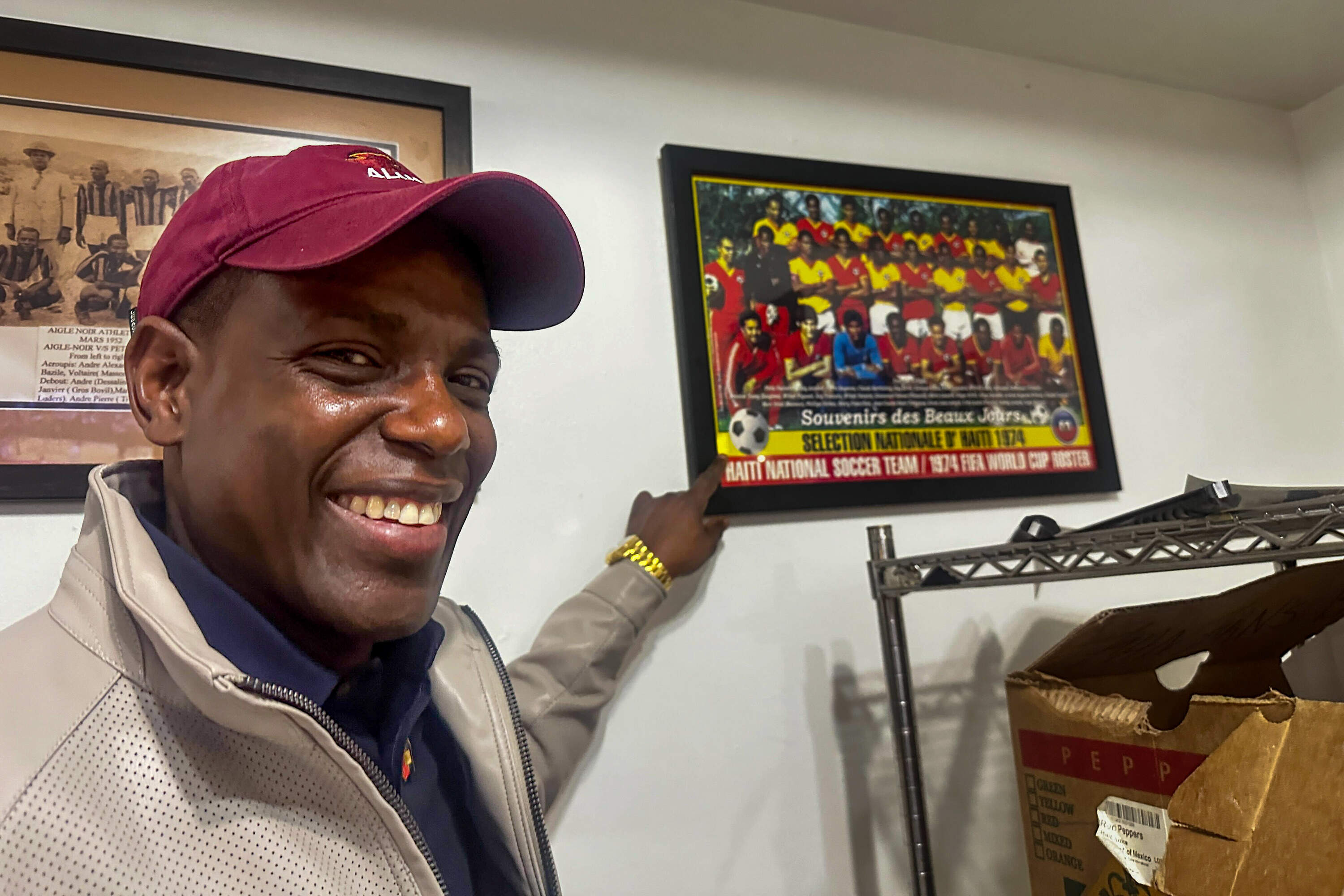 Wadner Pierre, of Foxborough, points to a picture of the Haitian soccer team from the early 1970s, the only other Haiti squad to qualify for the World Cup. (Simón Rios/WBUR)