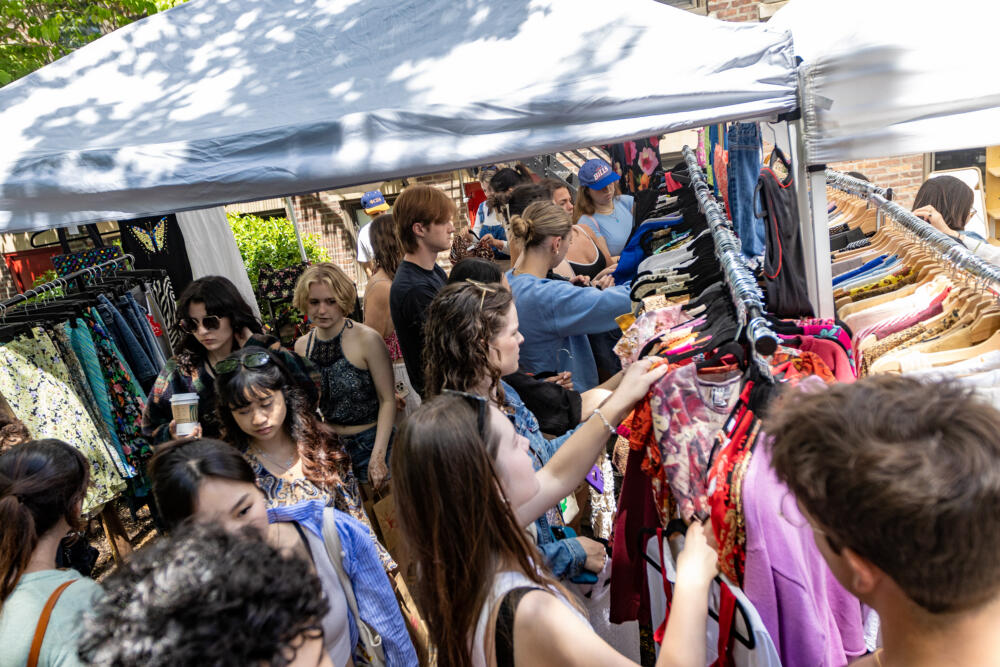 Festival goers rummage through clothing at the 1734 Thrift tent at the Street Fair at The WBUR Festival in 2025. (Jesse Costa/WBUR)