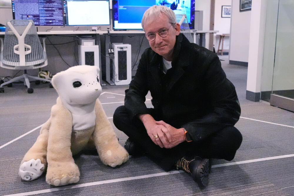 Colin Angle, co-founder and former CEO of Roomba vacuum maker, poses with Familiar, a prototype AI pet robot in Woburn, Mass. (Charles Krupa/AP)