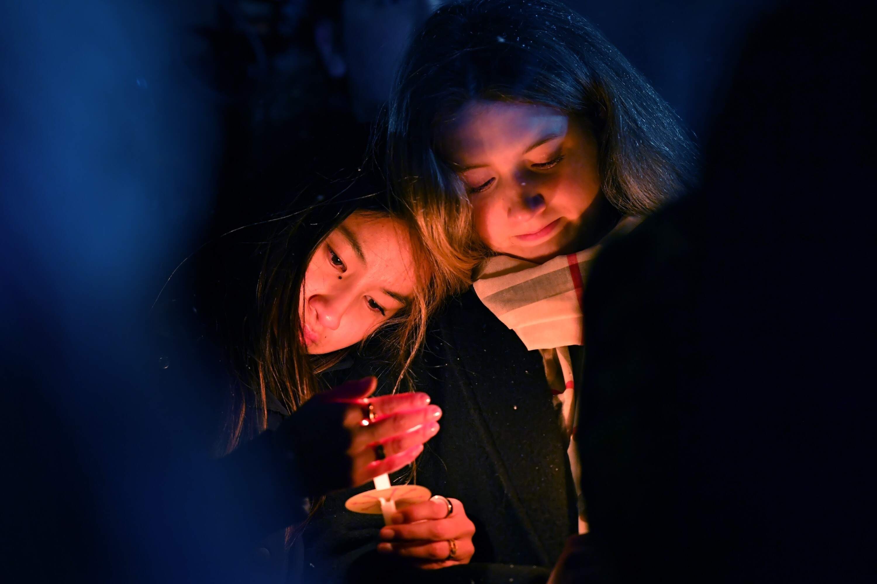 Two women hold candles during a vigil in Providence, R.I., for those injured or killed in the previous day's shooting on the campus of Brown University, Sunday, Dec. 14, 2025. (Steven Senne, File/AP)