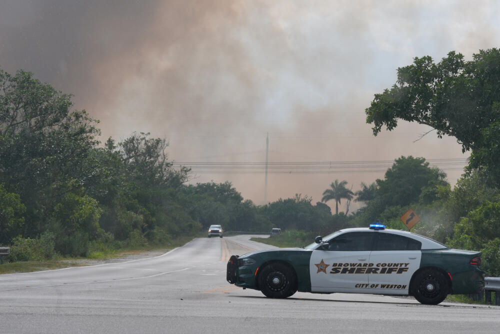 A Broward County Sheriff's police car blocks the entrance to a park as a wildlife burns in Broward County, Fla., Monday, May 11, 2026. (Marta Lavandier/AP)