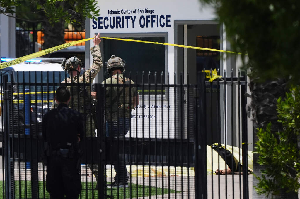 A body is covered with a tarp at the scene of a shooting outside the Islamic Center of San Diego Monday, May 18, 2026. (Gregory Bull/AP)