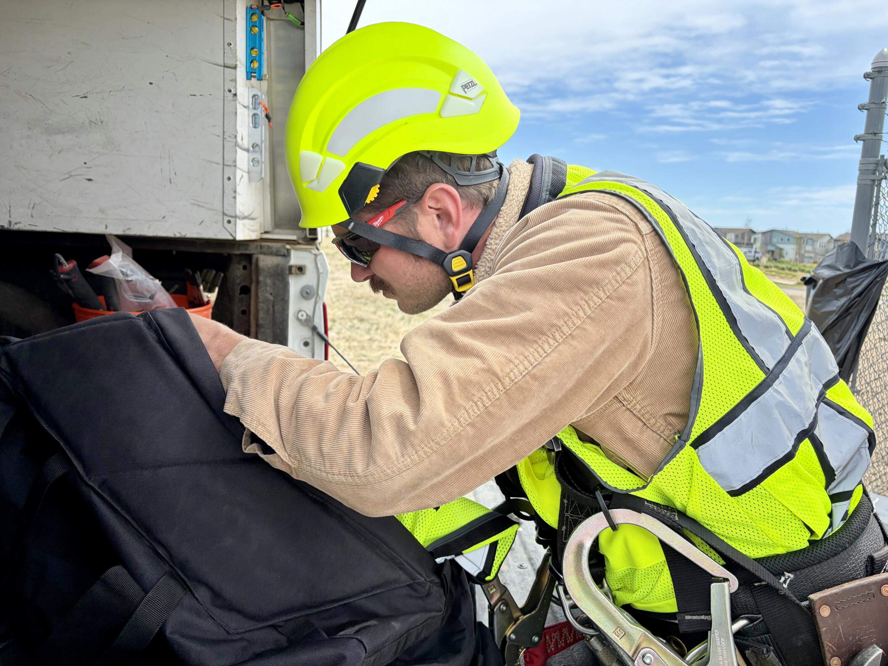 Cody Jones prepares to climb a cell tower in Aurora, Colorado, equipped with Pano AI cameras. The facility is run by American Tower. (Peter O’Dowd/Here & Now)