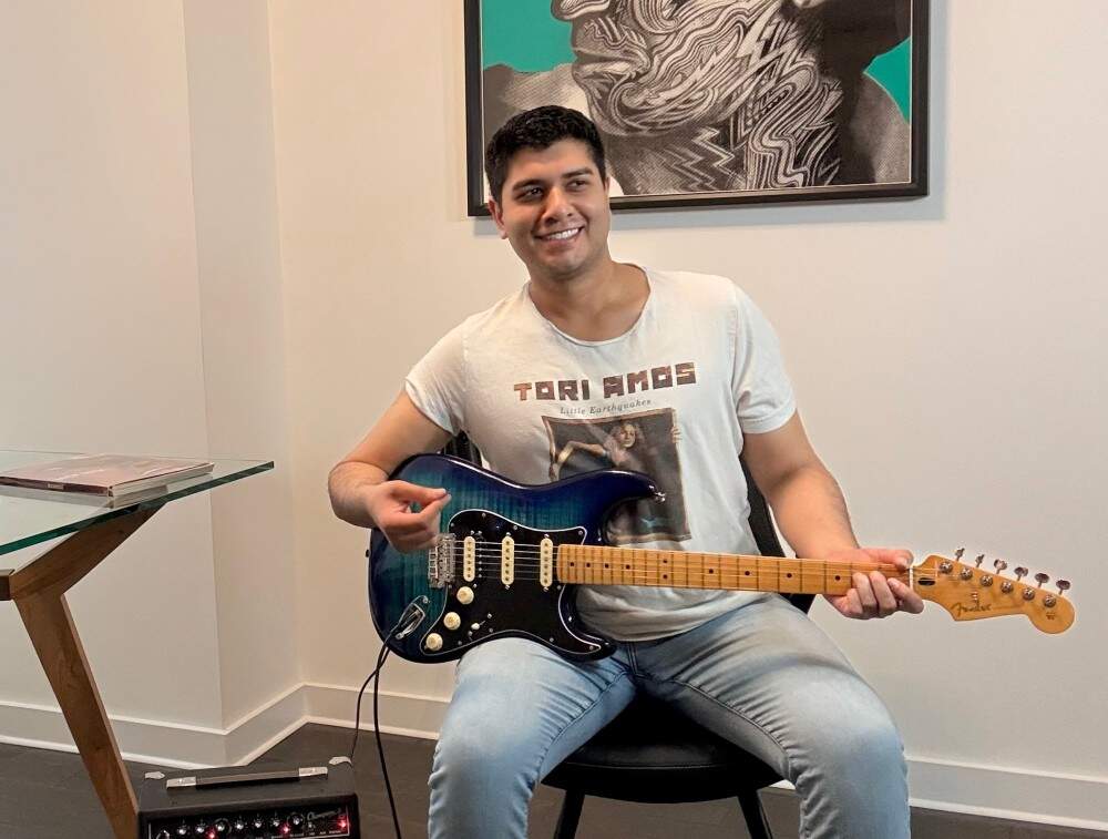 The author wearing a Tori Amos t-shirt and playing guitar. (Courtesy Kaivan Shroff)