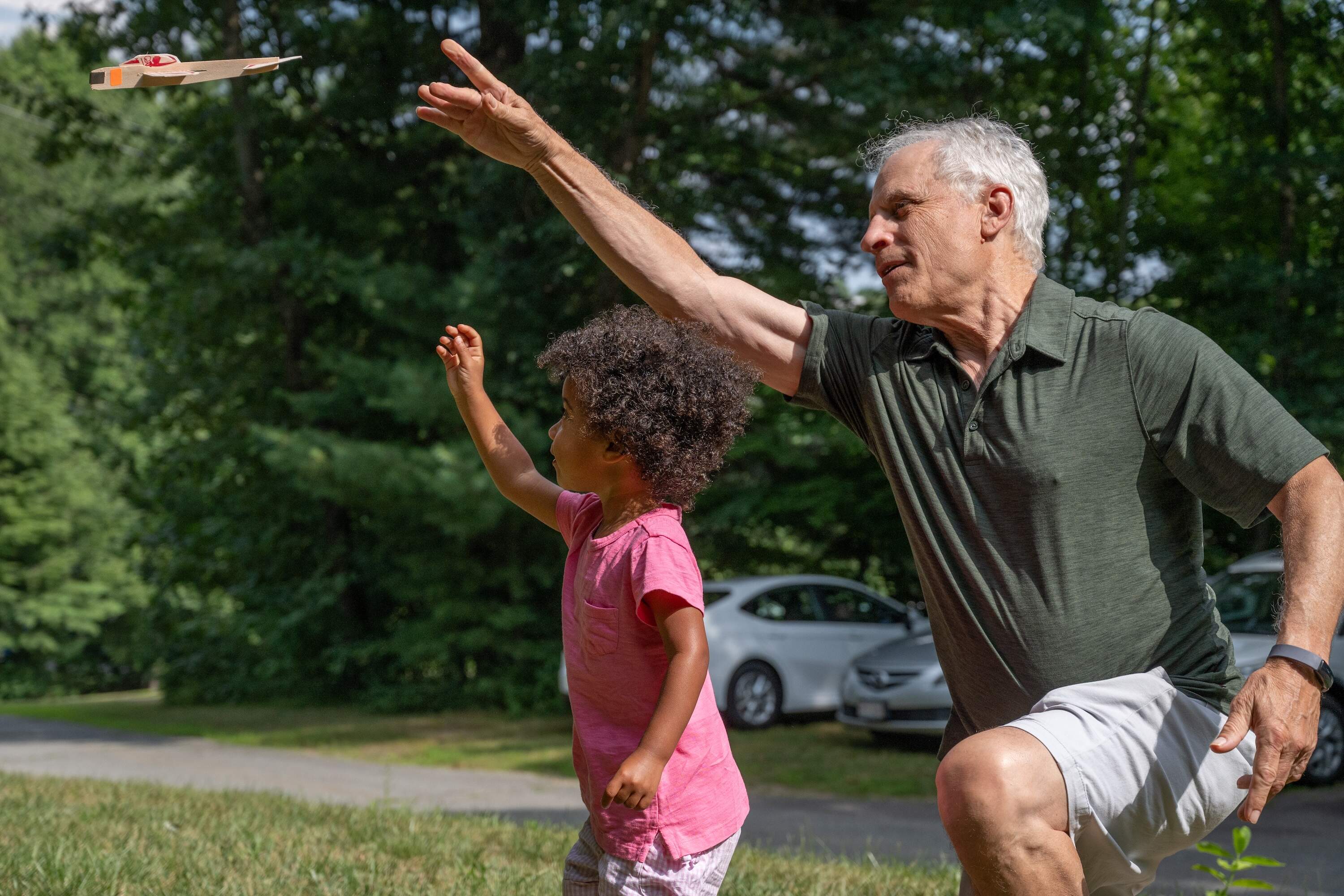 Forest Debbs and her grandfather fly a Guillow's glider in Framingham (Sharon Brody/WBUR)