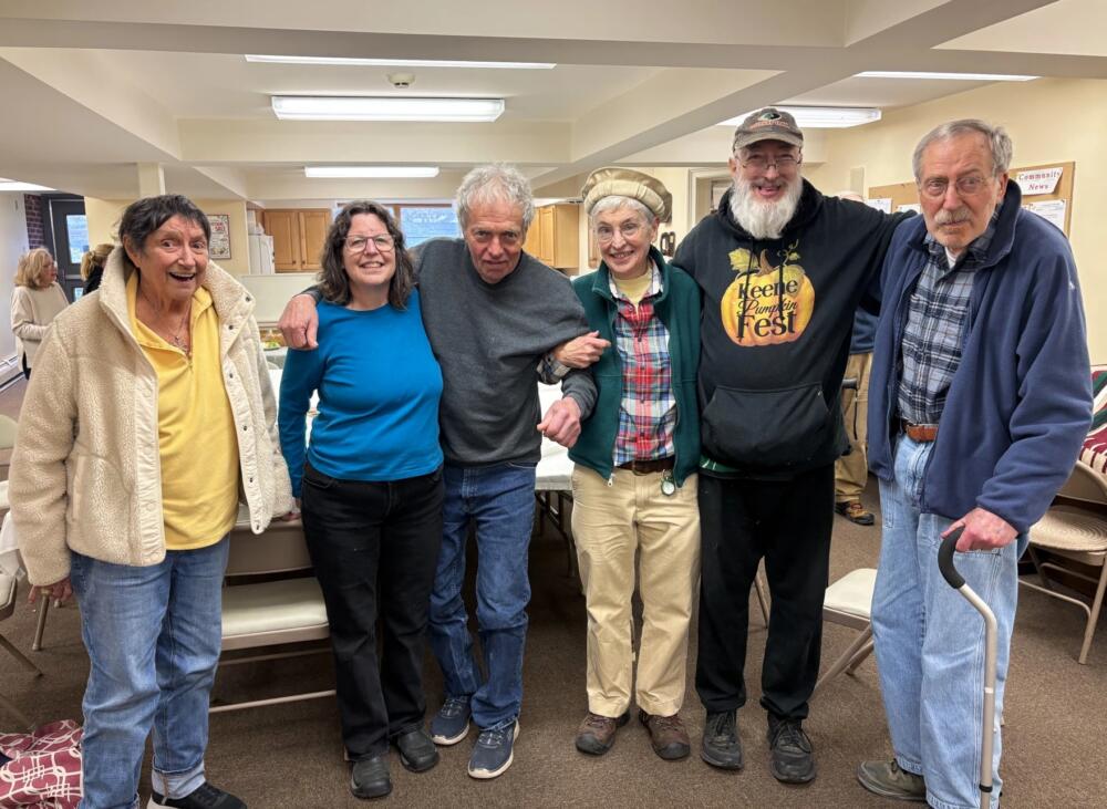 Several of those who attend a memory cafe in Chester stand together after a recent sing-a-long. Many said the music and sense of community keep them coming back. (Nina Keck/Vermont Public)