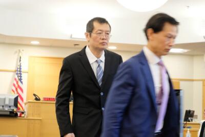 Yi Sun, left, with his attorney Mingli Chen, right, at the conclusion of a hearing in Rockingham Superior Court on April 23, 2026. County prosecutors recently dropped charges against Sun for allegedly running two warehouses in Seabrook after they were unable to work with federal agents to turn over evidence in the case. (Todd Bookman/NHPR)