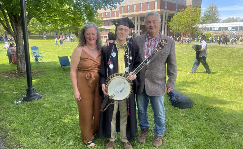 William “Wolfie” Krebs, a Hampshire College graduate part of the Class of 2026, poses with his mom and dad on May 16. (Nirvani Williams/NEPM)
