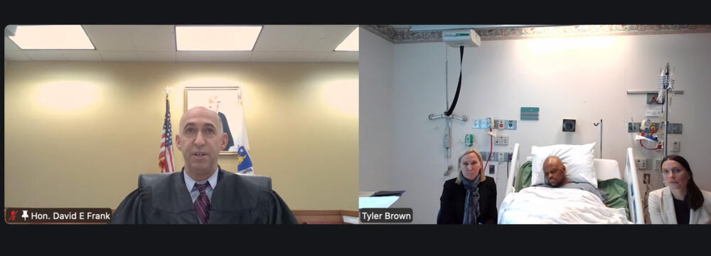 Tyler Brown appeared from a hospital bed for a virtual arraignment on Thursday. (Screenshot of Zoom)