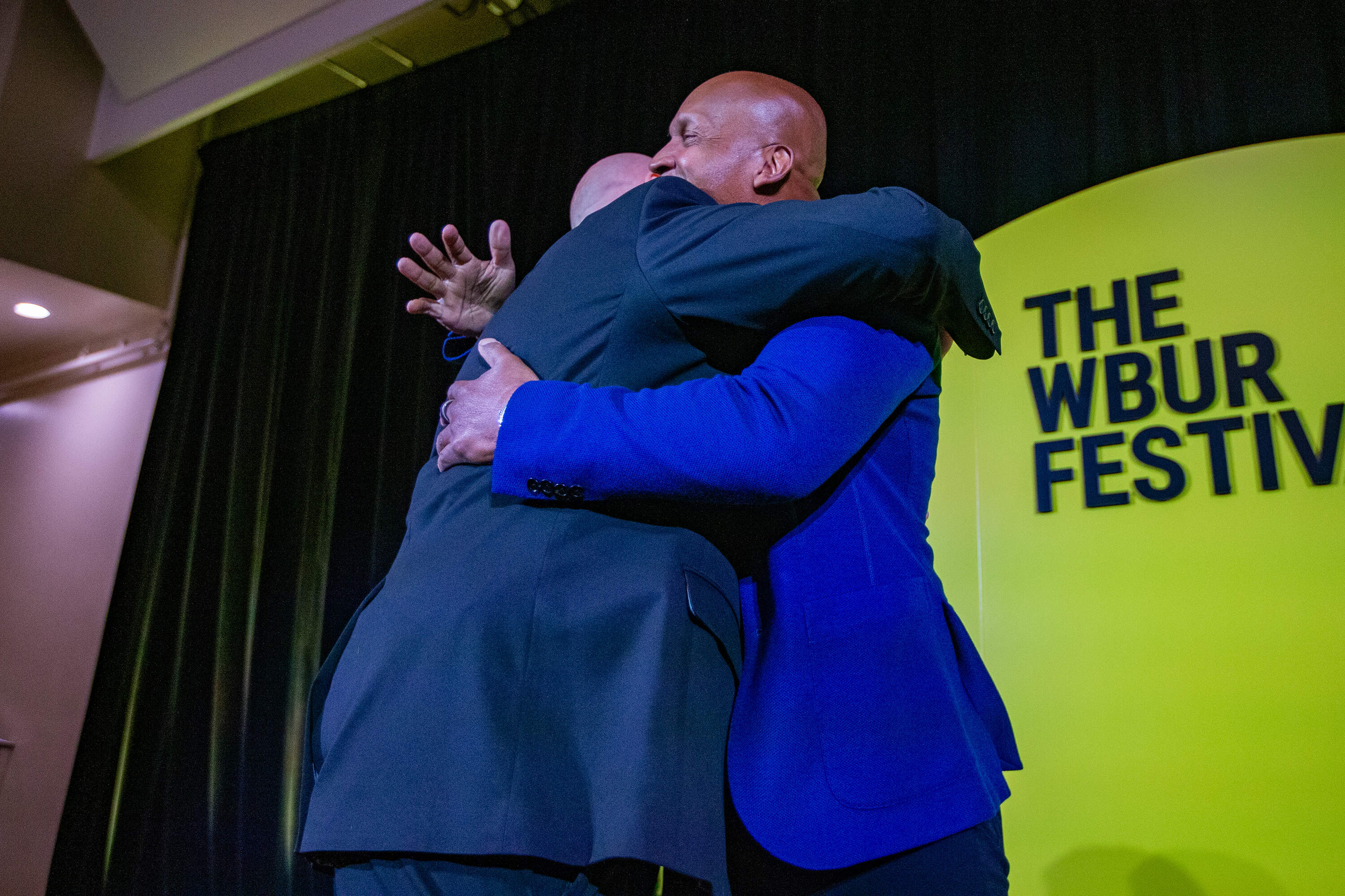 Joe Donovan and Founder of the Equal Justice Initiative Bryan Stevenson embrace ahead of a talk Stevenson gave at The WBUR Festival. (Jesse Costa/WBUR)