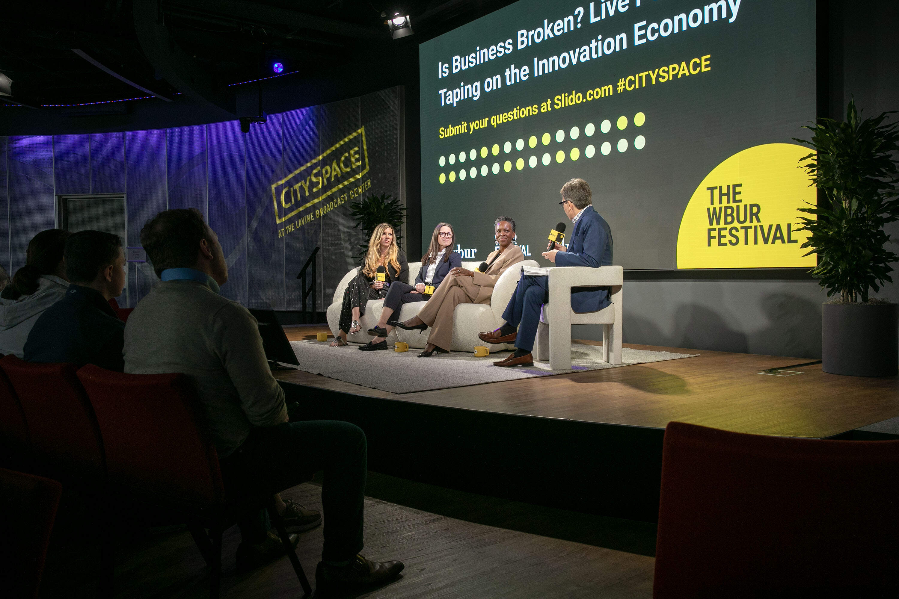 "Is Business Broken?" podcast host Curt Nickisch speaks with Kendalle Burlin O'Connell, CEO of MassBio, Elizabeth Jurinka, director at Vistria PRG and Boston University President Melissa Gilliam at the WBUR Festival in Boston. (Robin Lubbock/WBUR)